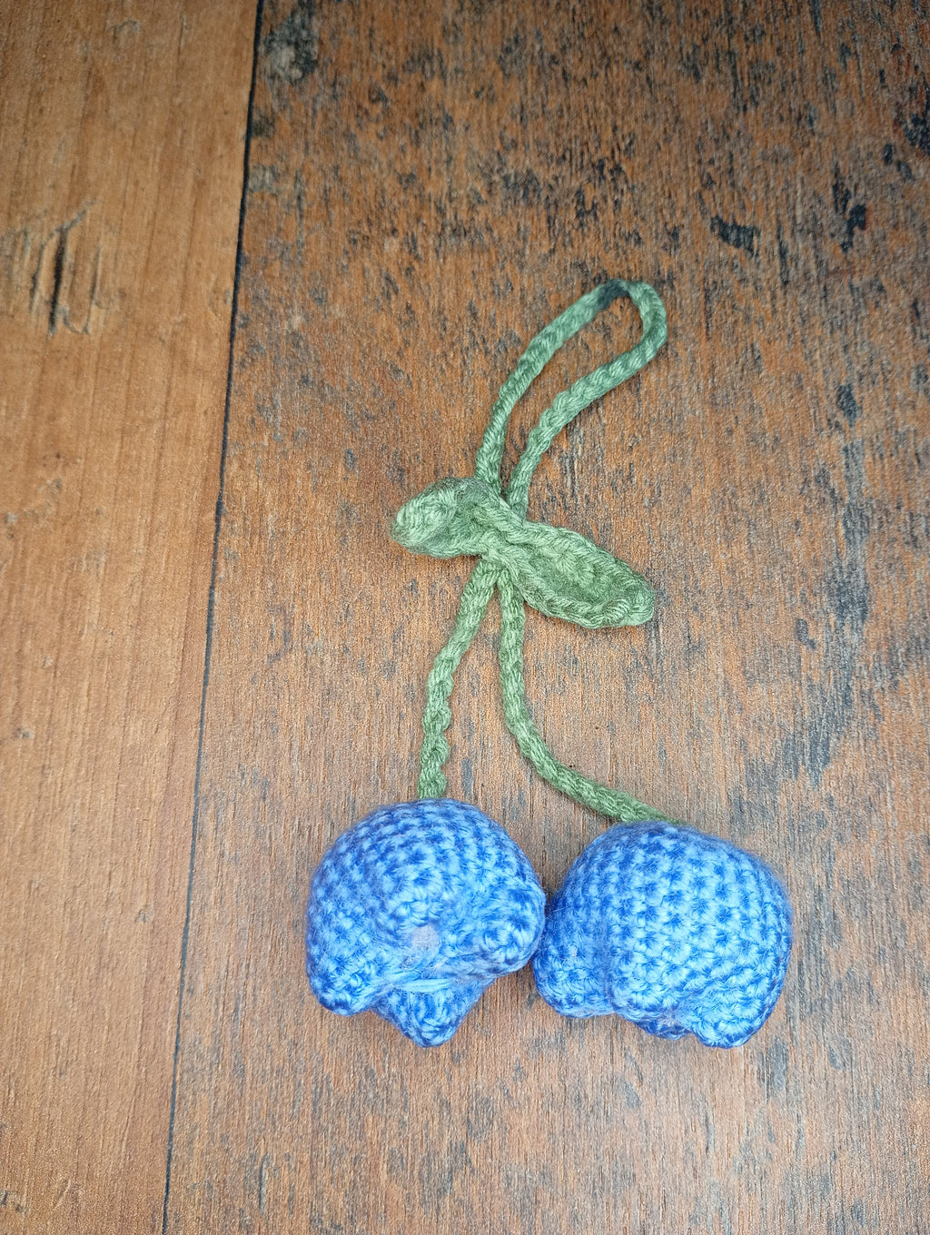 Gehäkelter Blaubeeren-Schlüsselanhänger aus blauem Garn mit grünem Stiel